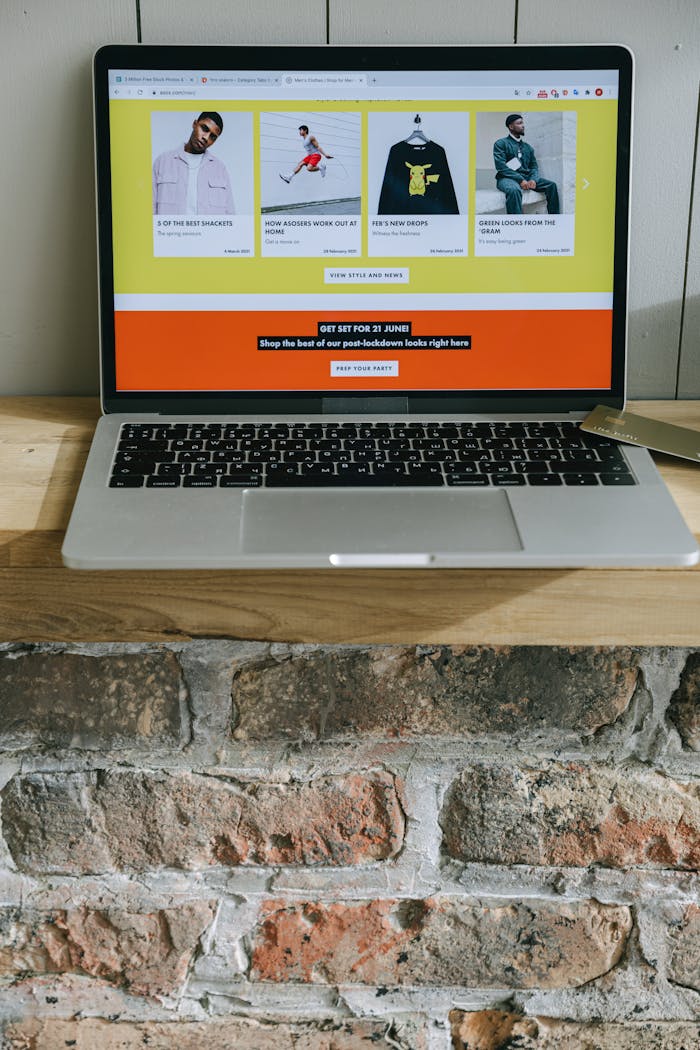 about-01 A laptop on a wooden shelf showing a colorful online shopping webpage.